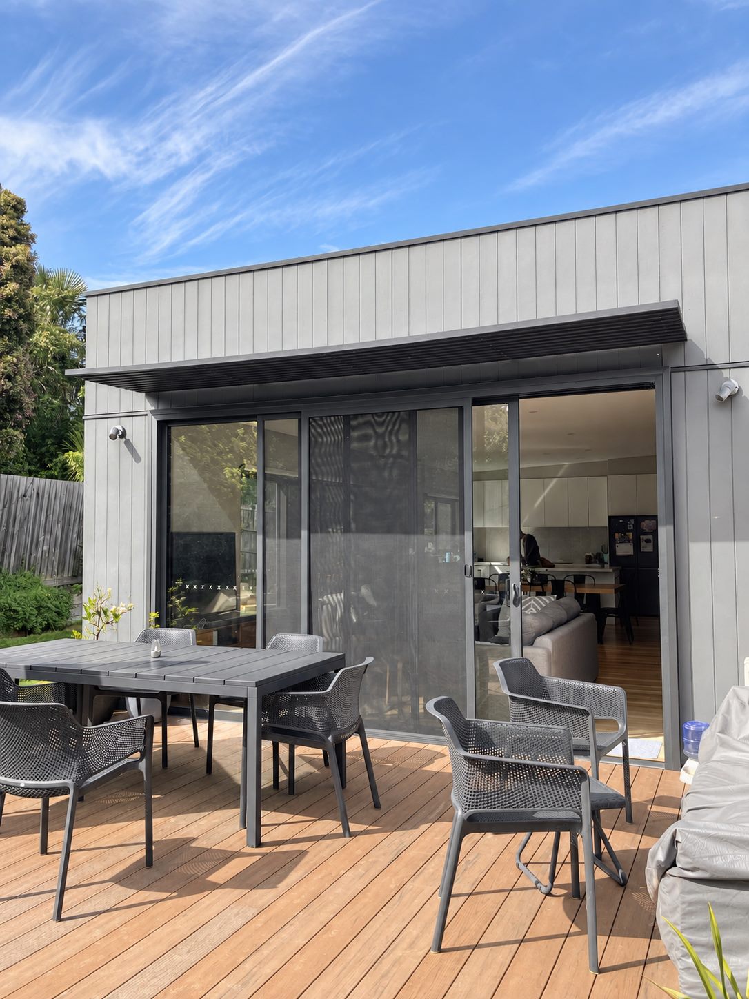 The deck off the living room, the sliding doors folded back into the kitchen